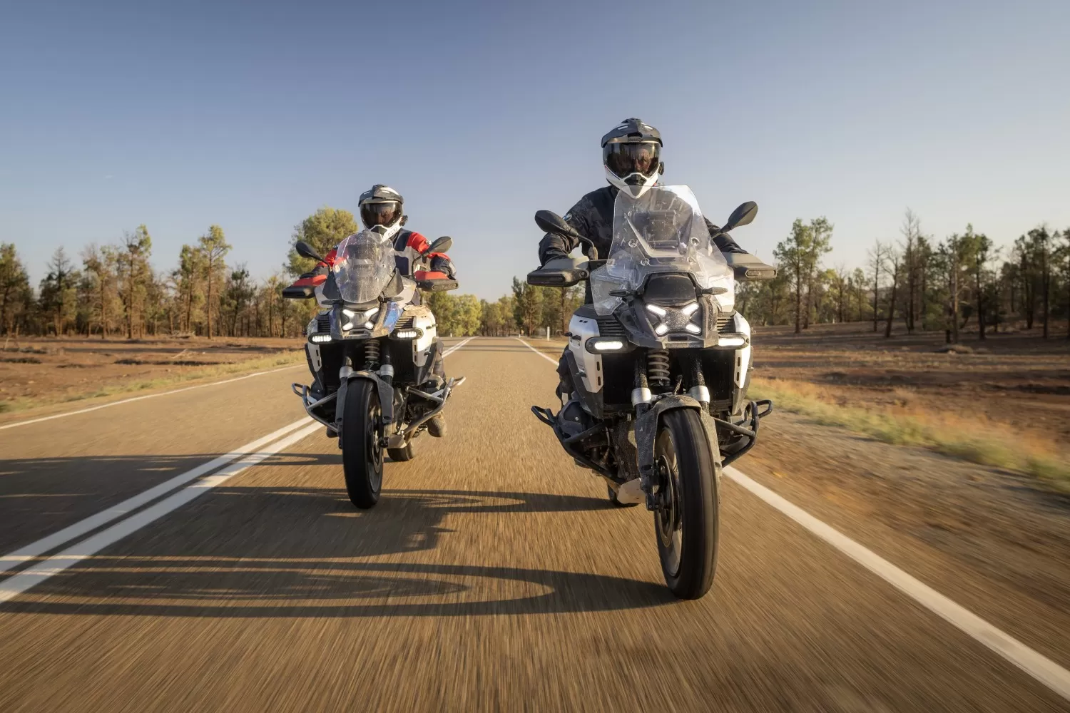Two BMW R 1300 GS Adventure bikes riding on the main road