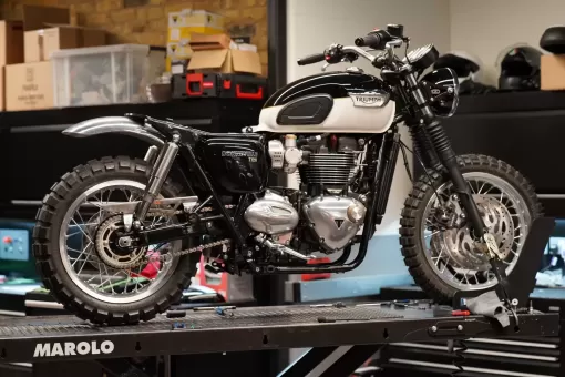 the-custom-grimsthorpe-growler-t120-mid-build-on-a-bench-inside-the-triumph-london-workshop.webp